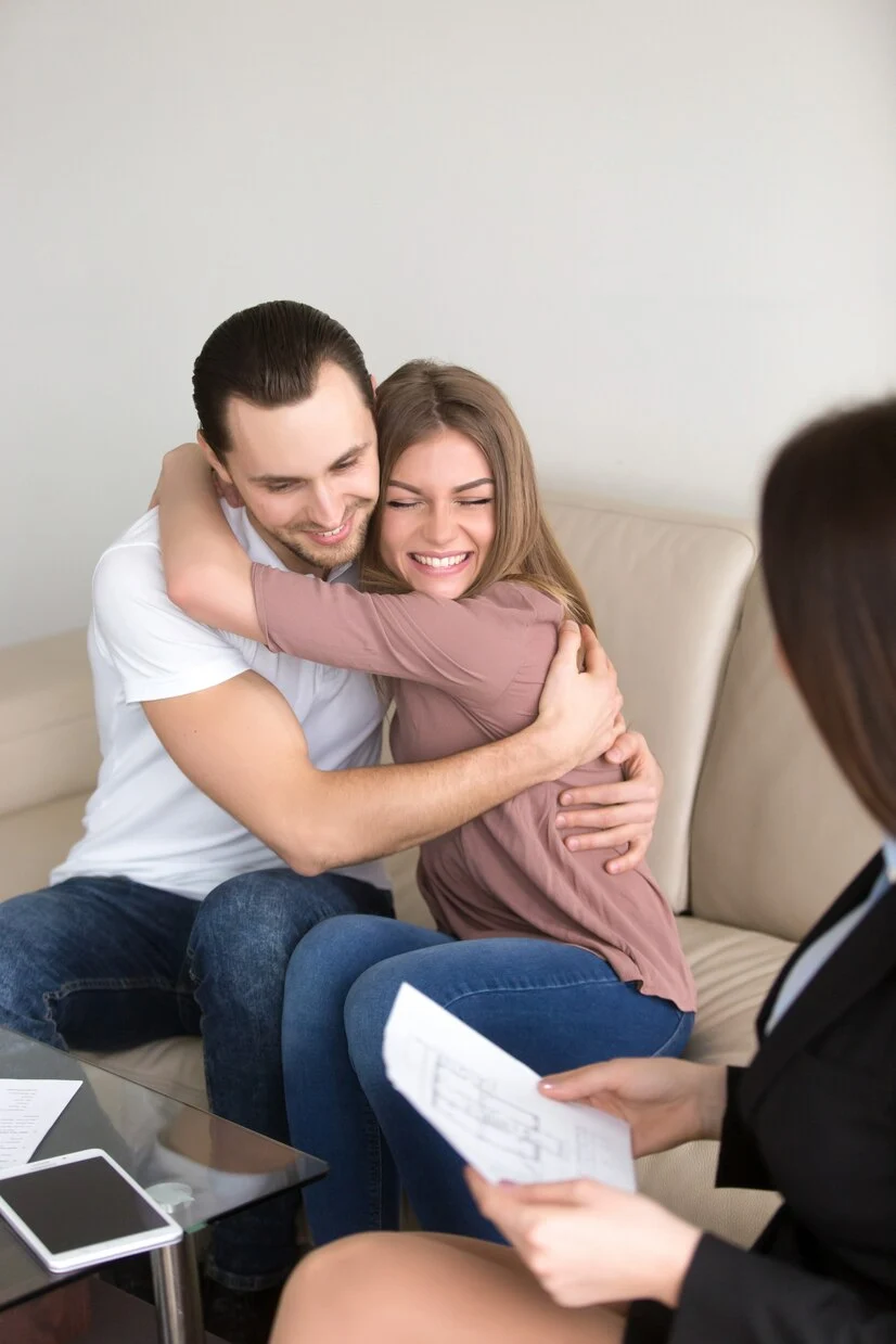 excited-couple-hugging-meeting-with-estate-agent-mortgage-investment